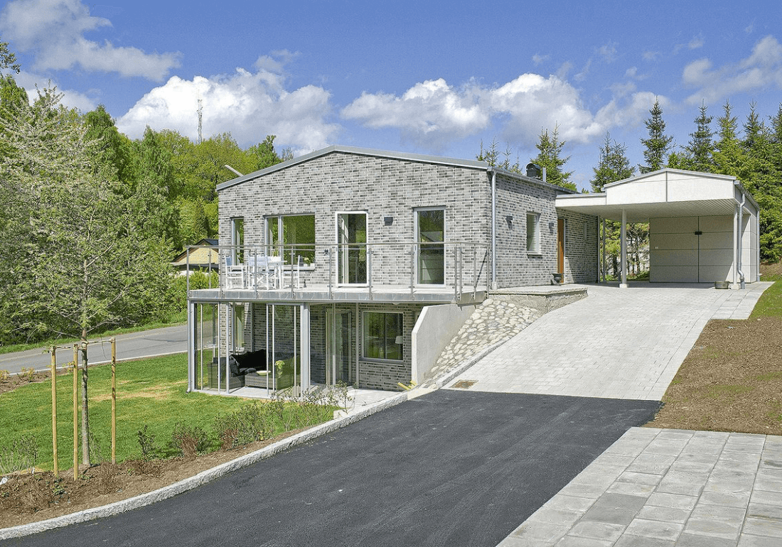Villa under nybyggnation med träfasad och stora fönster, byggt av Pålssons Bygg